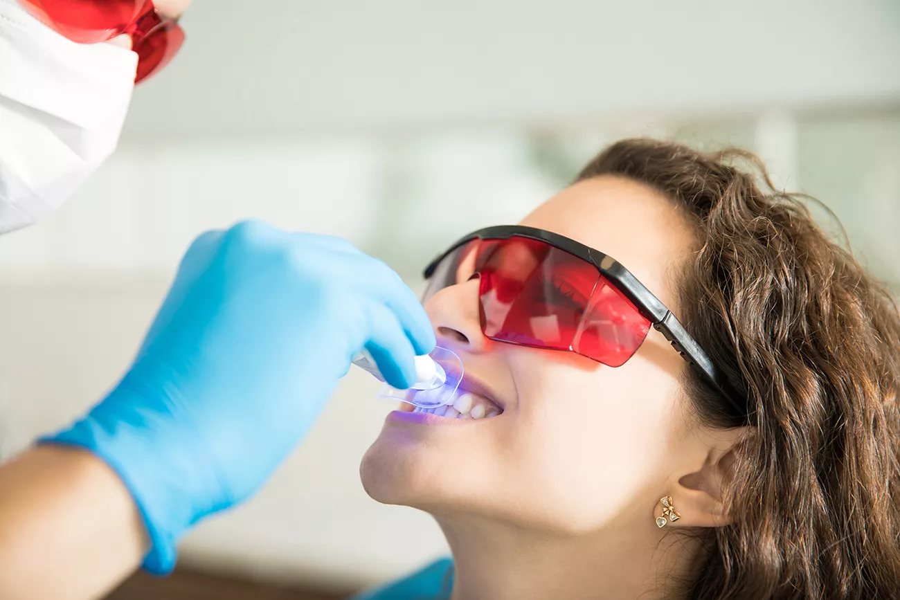 closeup-young-woman-having-her-teeth-whitened-with-ultraviolet-light-dental-clinic-1